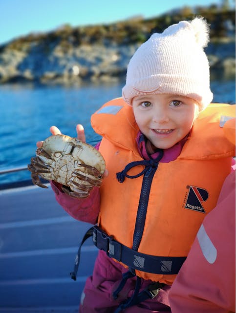 Tyra Våga viser stolt frem litt av teinefangsten, en flott krabbe.