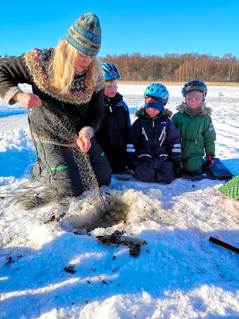 Astrid Wallem Hagen lærer bort kunsten å fiska med garn på isen. Når garnet bllir trekt er det stor spenning.
