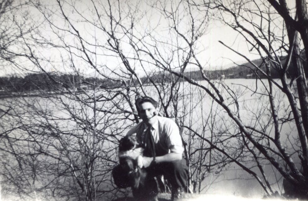 Olav Bøe (1925-2009) med pipe og hund. Ålfjorden i bakgrunnen.