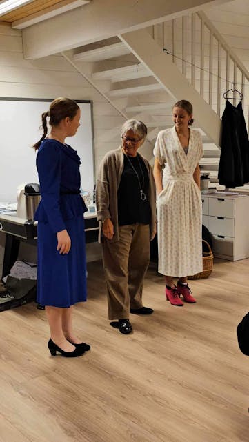 Her viser Anja Leirvik til venstre og Mathilde Haaversen til høgre kjolar frå Hauske Konfeksjon medan Randi Bøe fortel om modellar og stoff.