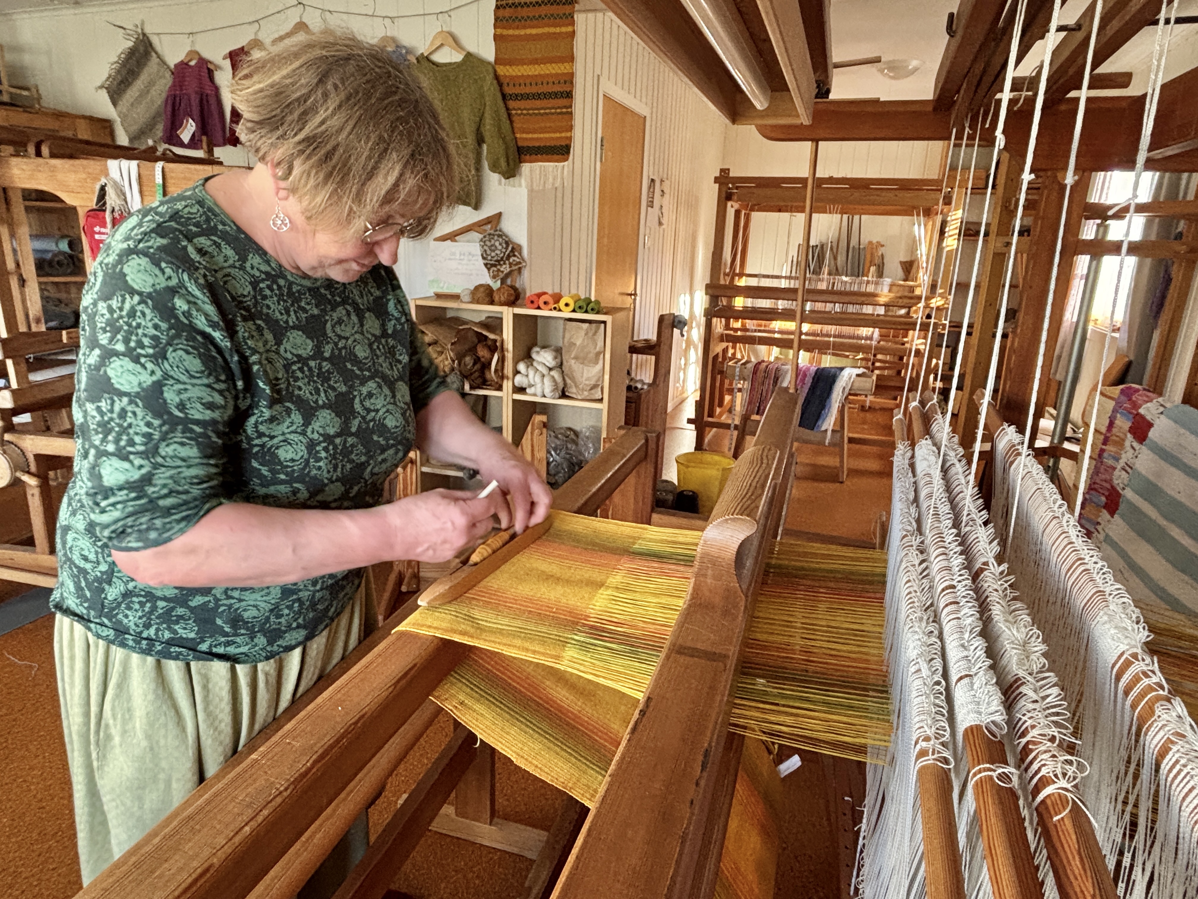 I Fartein Valens hus driv Elisabeth Husebø vevstova, som produserer ulikt handarbeid til gardsbutikken som ligg i vegg-i-vegg. Foto: Heidi Molstad Andresen / NPK