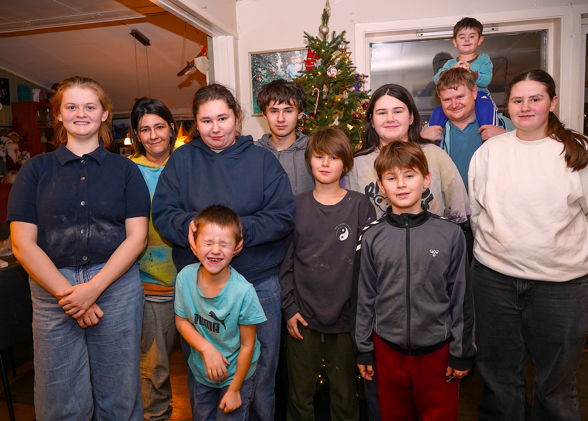 Heile storfamilien samla framfor juletreet. Frå venstre: Veronica (18), Karianne (43), Karoline (18), Jørgen (6), Martin (13), Teodor (11), Julie (14), Daniel (9), John Haktor (43), Noah (2) og Martine (16). Foto: Thomas Førde